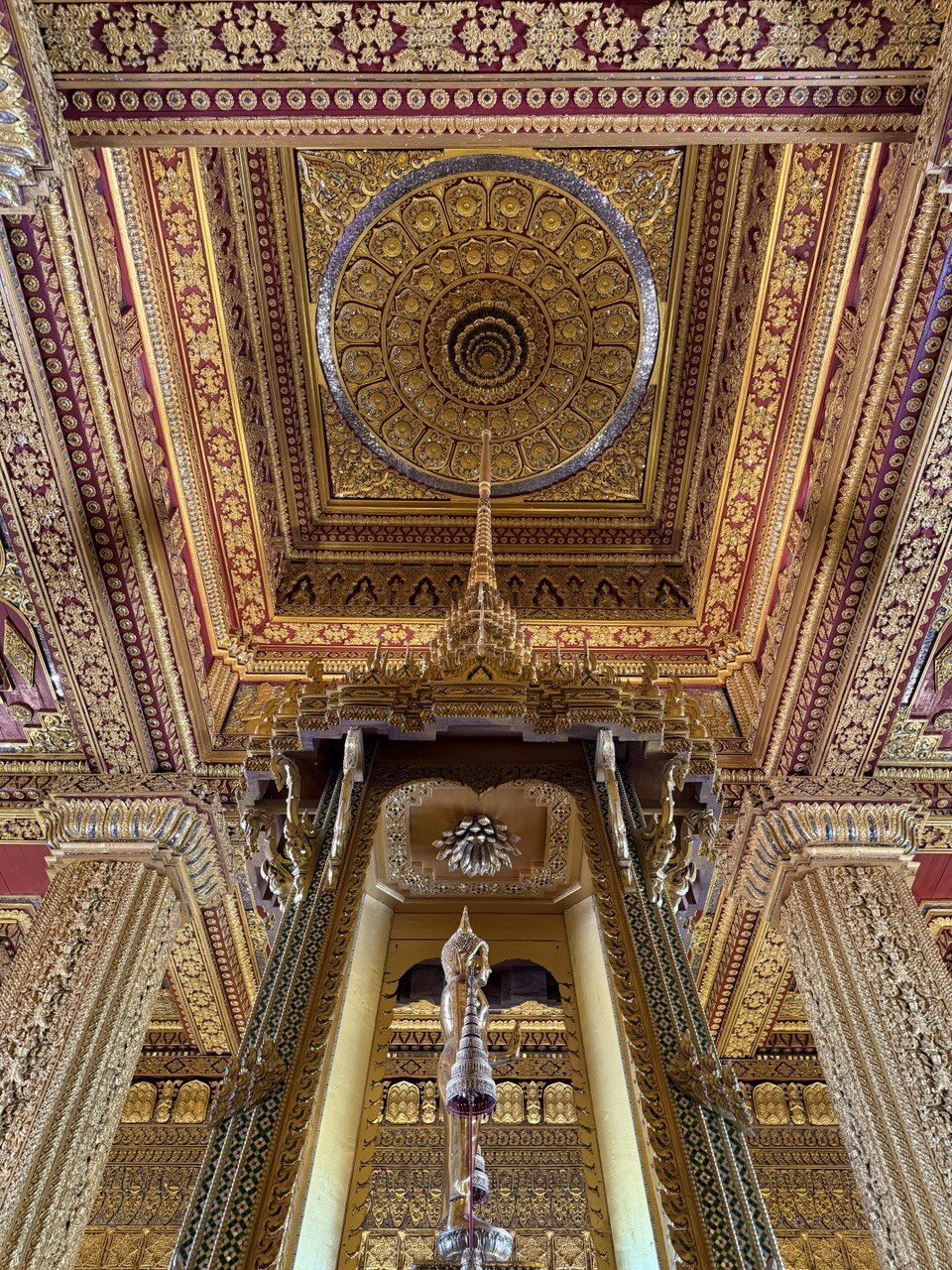 The intricate gilded ceiling and spire of a temple replica at the Ancient City near Bangkok